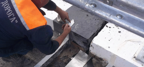 Designed to last: After installation of the stainless steel laminated bitumen sheets and the tear-resistant fabric mesh, the first layer of chippings is tamped in place. The finished roadway expansion joint offers exceptional reliability.